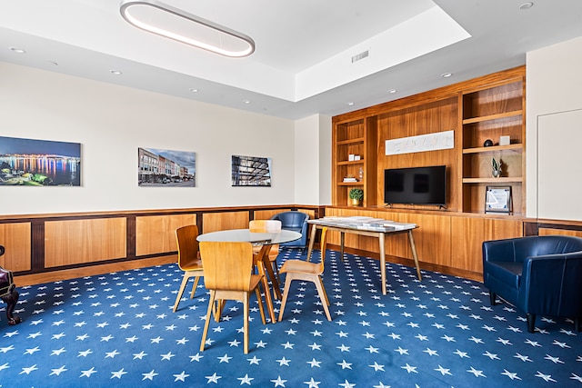 dining room featuring dark colored carpet and built in shelves