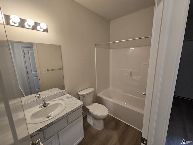 full bathroom with toilet,  shower combination, wood finished floors, and vanity