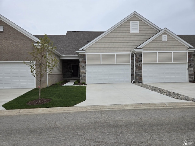 803 Plum Village Dr, Monroe, MI 48161 - craftsman-style house with a front yard, stone siding, a garage, driveway, and a shingled roof