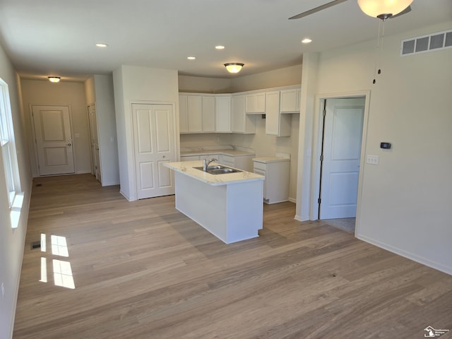 807 Plum Village Dr, Monroe, MI 48161 - kitchen featuring a sink, white cabinets, an island with sink, ceiling fan, and light wood-style flooring