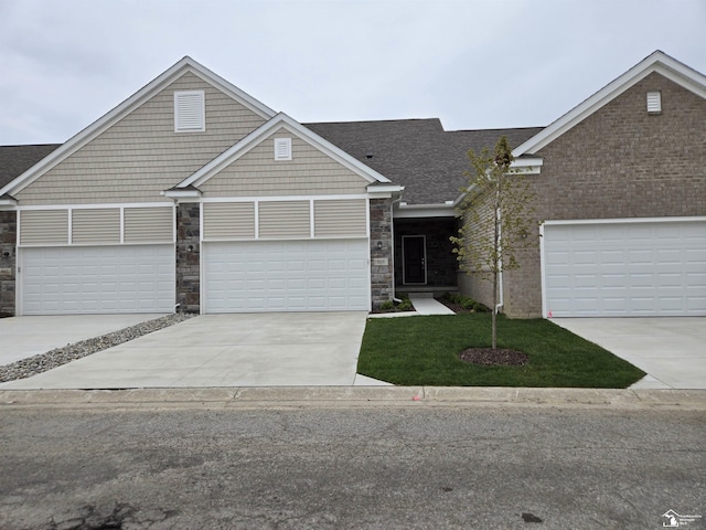 805 Plum Village Dr, Monroe, MI 48161 - craftsman house with a front yard, stone siding, concrete driveway, and a garage