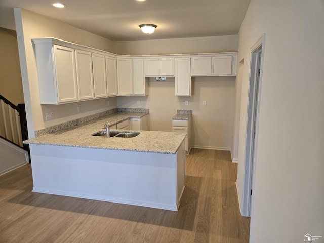 805 Plum Village Dr, Monroe, MI 48161 - kitchen featuring a sink, a peninsula, wood finished floors, white cabinets, and recessed lighting
