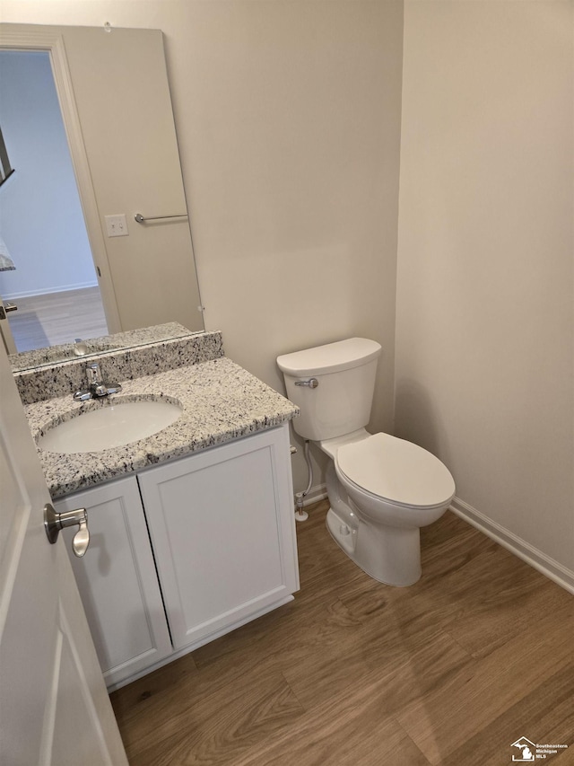 805 Plum Village Dr, Monroe, MI 48161 - half bathroom with baseboards, toilet, wood finished floors, and vanity