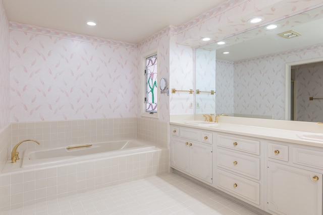 bathroom featuring tile patterned flooring, vanity, and tiled bath