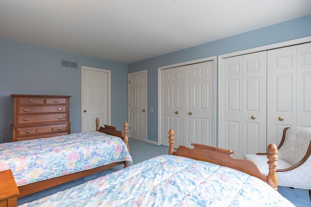 carpeted bedroom featuring two closets