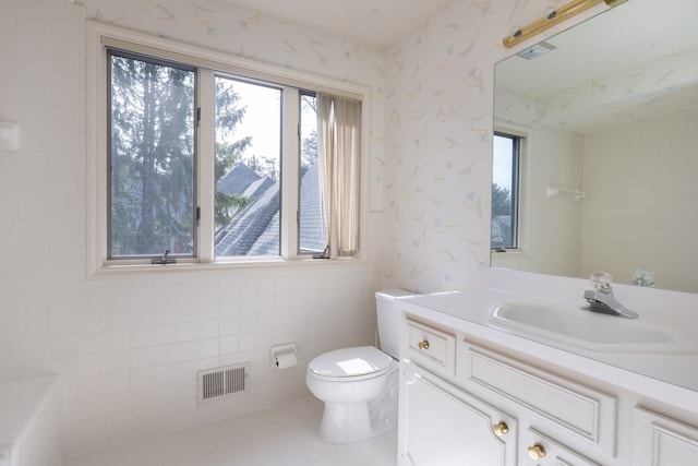 bathroom with plenty of natural light, toilet, and vanity