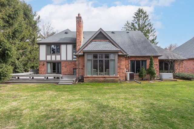 rear view of property with central AC unit, a wooden deck, and a lawn