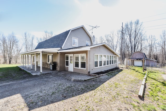 back of property featuring a garage and an outdoor structure