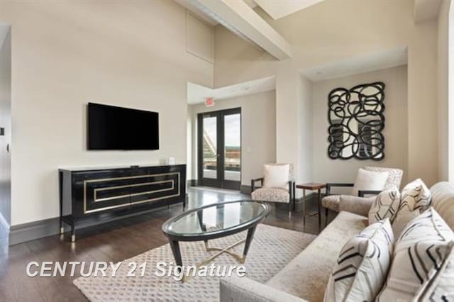 living room with dark hardwood / wood-style flooring, a towering ceiling, and french doors