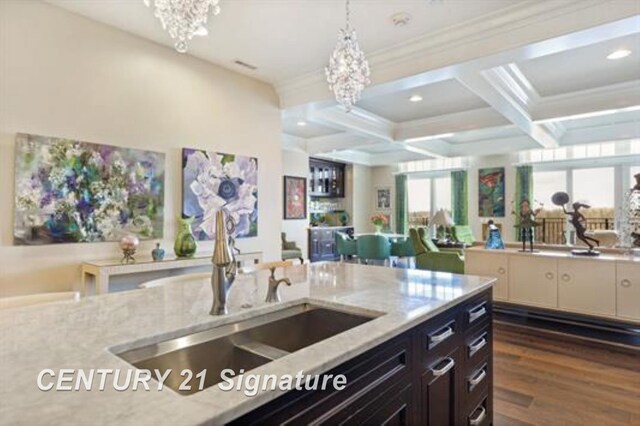 110 E Main St, Midland, MI 48640 - kitchen with a sink, a chandelier, coffered ceiling, light stone countertops, and ornamental molding