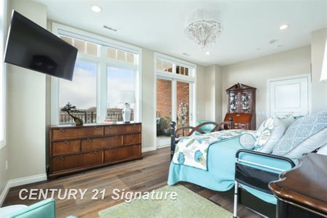 bedroom with hardwood / wood-style floors and an inviting chandelier