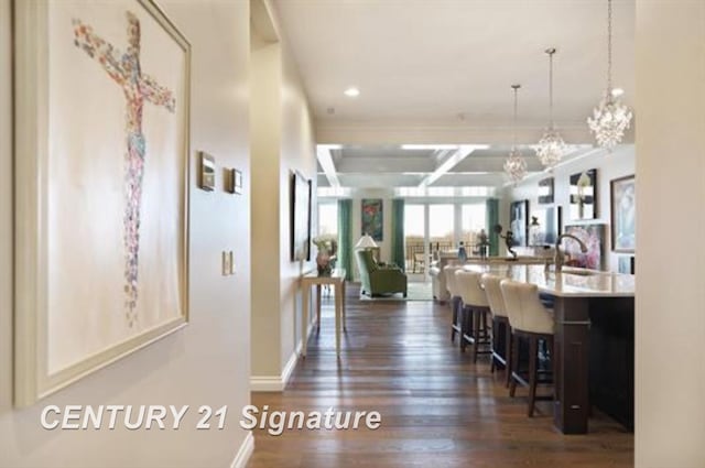 hall with sink, dark hardwood / wood-style flooring, coffered ceiling, and a notable chandelier