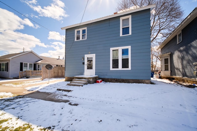 view of snow covered rear of property