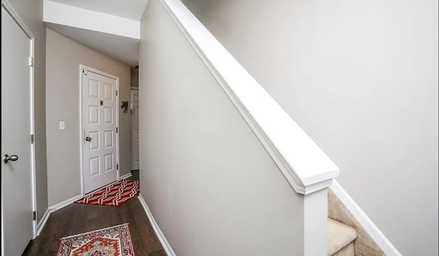 interior space featuring baseboards, dark wood-type flooring, and stairs