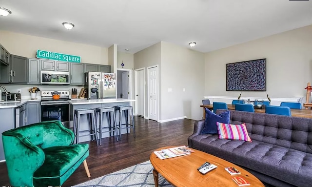 living room with baseboards and dark wood-style floors