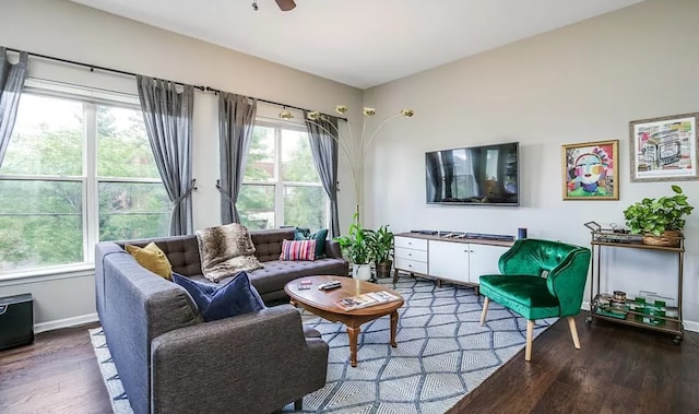 living room featuring ceiling fan, baseboards, and wood finished floors