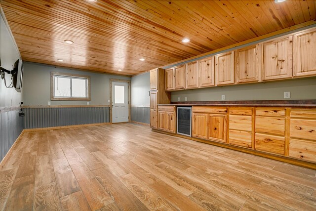 9363 S Grow Rd, Greenville, MI 48838 - kitchen featuring beverage cooler, wooden ceiling, dark countertops, a wainscoted wall, and light wood-style floors