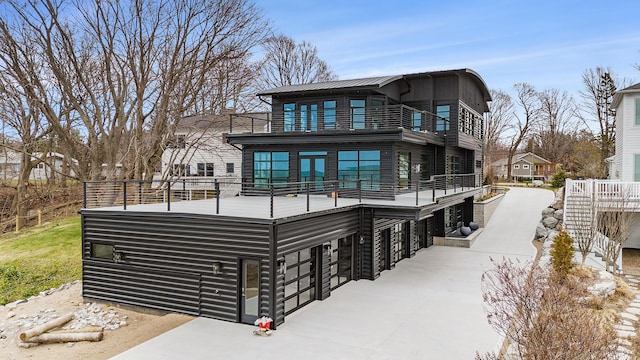 443 N Shore Dr, South Haven, MI 49090 - back of house with a balcony, an attached garage, metal roof, and driveway
