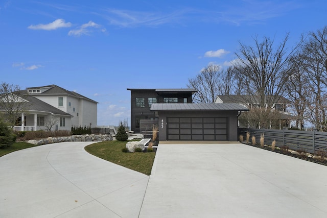 443 N Shore Dr, South Haven, MI 49090 - modern home featuring concrete driveway, metal roof, an attached garage, and a standing seam roof