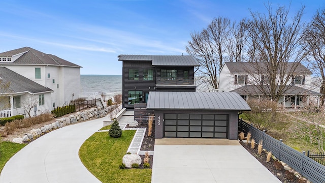 443 N Shore Dr, South Haven, MI 49090 - view of front of house featuring a water view, metal roof, concrete driveway, and an attached garage
