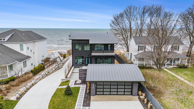443 N Shore Dr, South Haven, MI 49090 - view of front facade with a water view, concrete driveway, metal roof, an attached garage, and a balcony