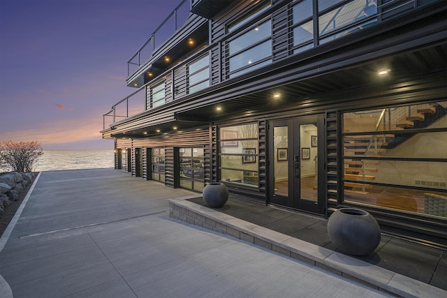 443 N Shore Dr, South Haven, MI 49090 - patio terrace at dusk with view of water and beach, french doors, and a garage