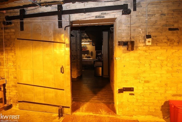 corridor featuring wood-type flooring and brick wall