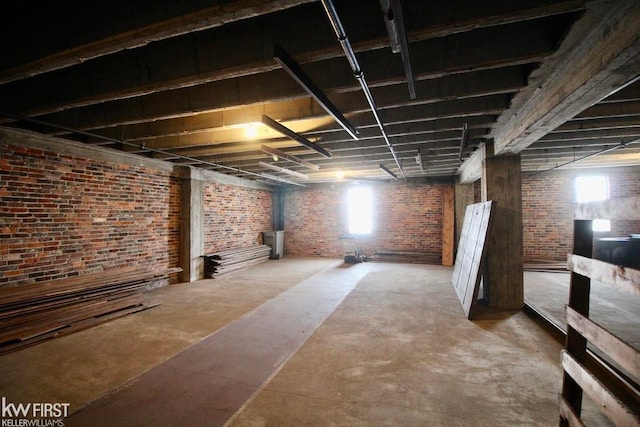 basement featuring a wood stove and brick wall