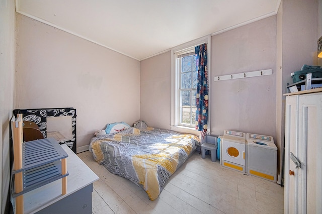 bedroom featuring washer and clothes dryer and light wood-type flooring