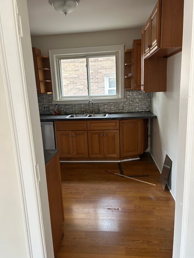 kitchen featuring stainless steel dishwasher, dark hardwood / wood-style flooring, sink, and tasteful backsplash