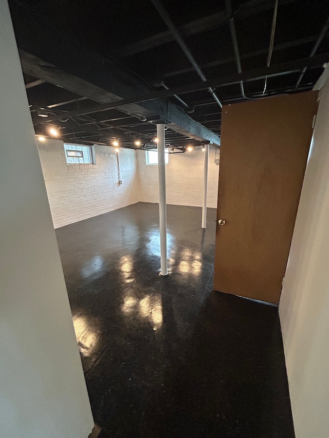 basement featuring brick wall