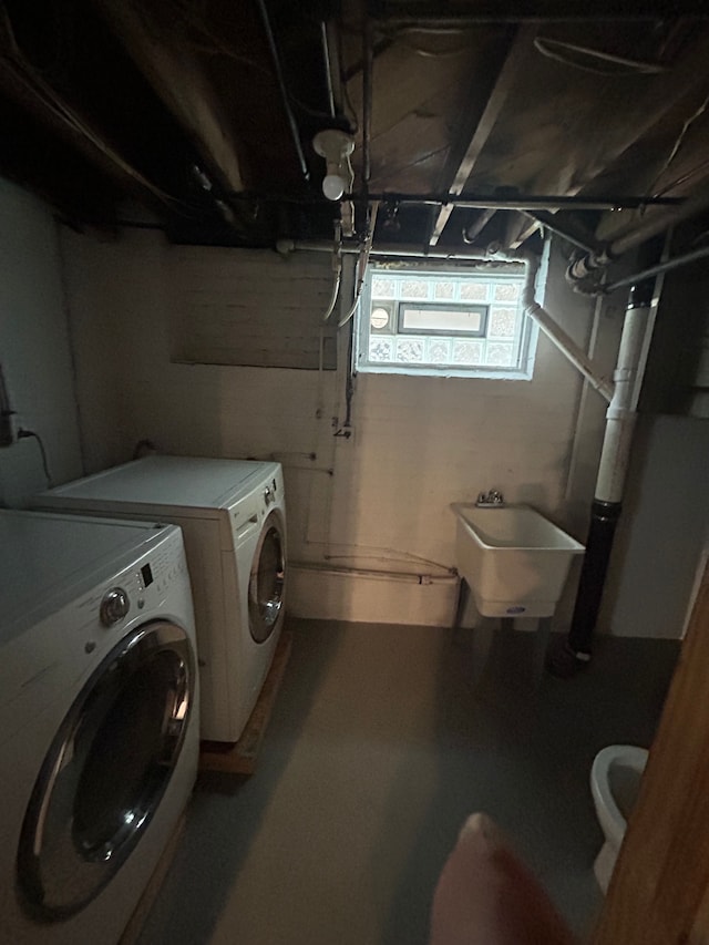 laundry area with separate washer and dryer and sink