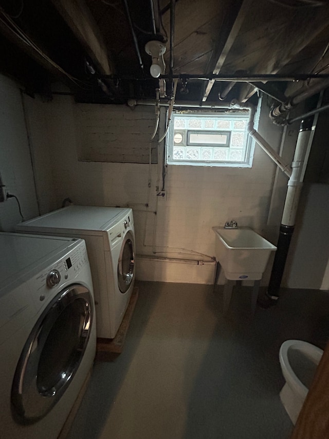 clothes washing area with washer and dryer and sink