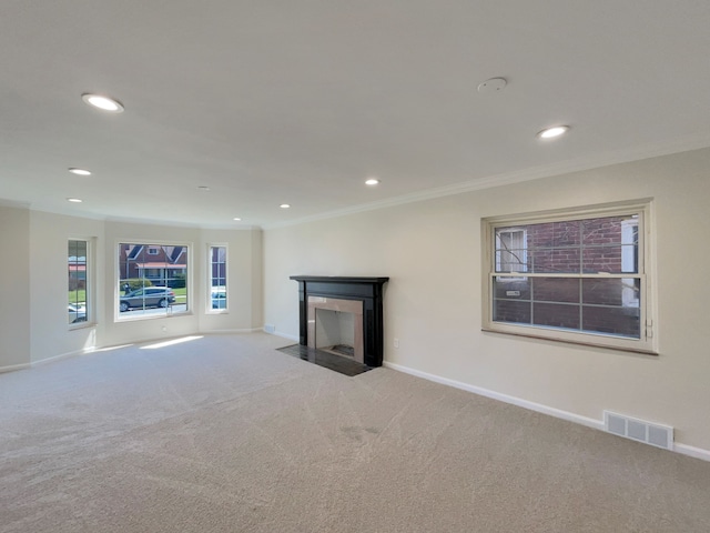 unfurnished living room featuring carpet flooring and ornamental molding