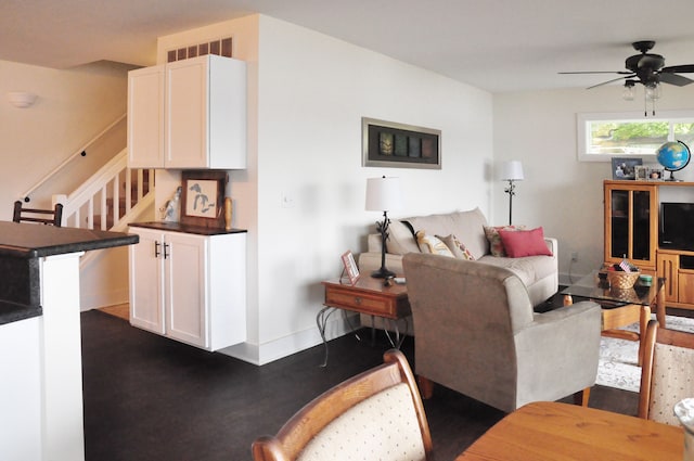 living room featuring ceiling fan and dark wood-type flooring