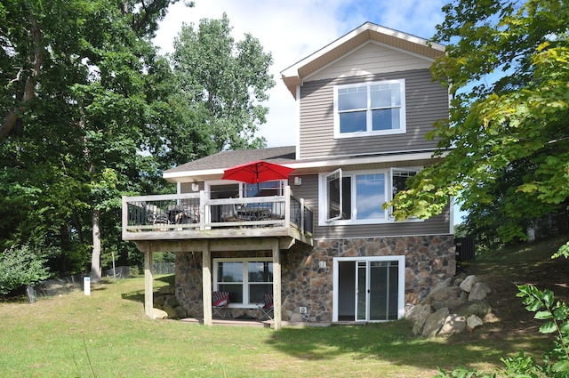 back of property with a yard and a wooden deck