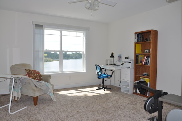 office with carpet floors, ceiling fan, and a water view