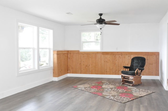 unfurnished room with ceiling fan, dark wood-type flooring, and a wealth of natural light