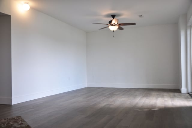 spare room with ceiling fan and dark wood-type flooring