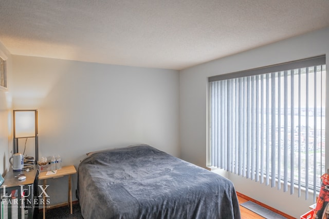 bedroom with a textured ceiling and hardwood / wood-style flooring