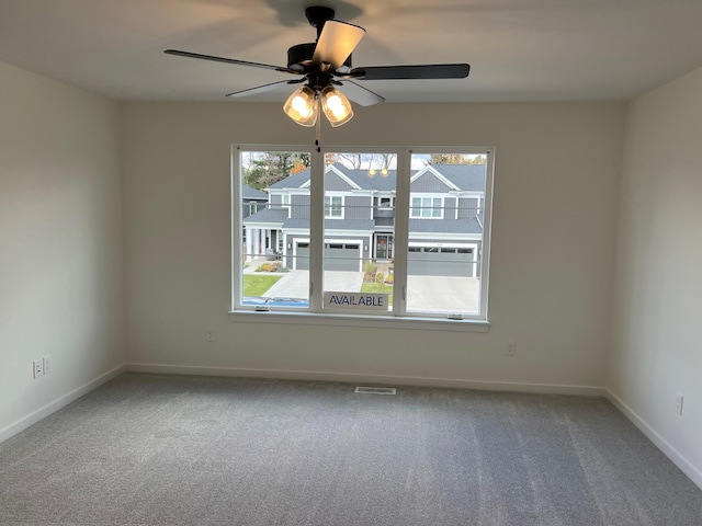 carpeted spare room featuring ceiling fan