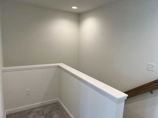 hallway with dark colored carpet