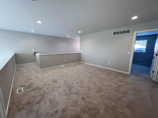 spare room with carpet, visible vents, and recessed lighting