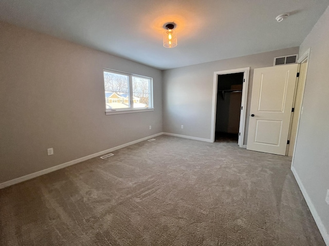 unfurnished bedroom with carpet, visible vents, and baseboards