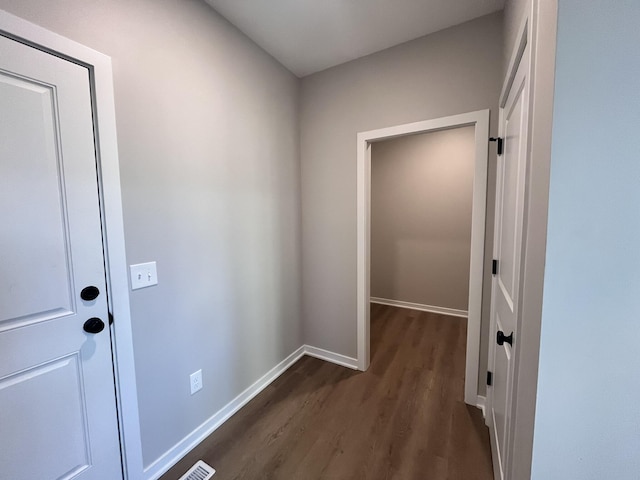 hallway with dark wood-style floors and baseboards