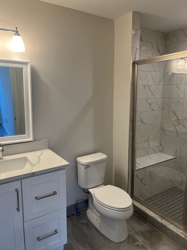 bathroom with vanity, toilet, and a shower with shower door