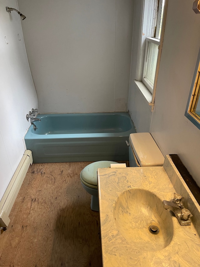 bathroom featuring toilet, a washtub, and sink