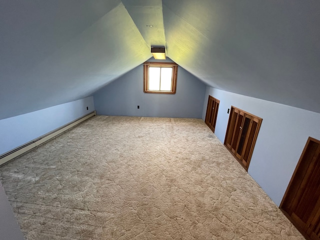 additional living space with carpet floors, vaulted ceiling, and a baseboard heating unit