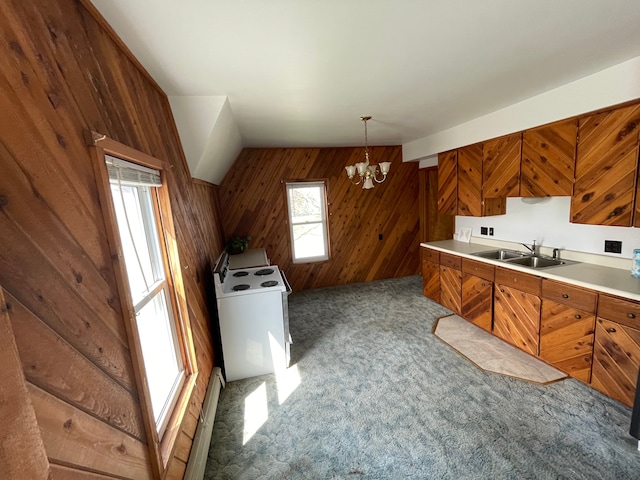 kitchen featuring pendant lighting, wood walls, an inviting chandelier, white range with electric cooktop, and sink