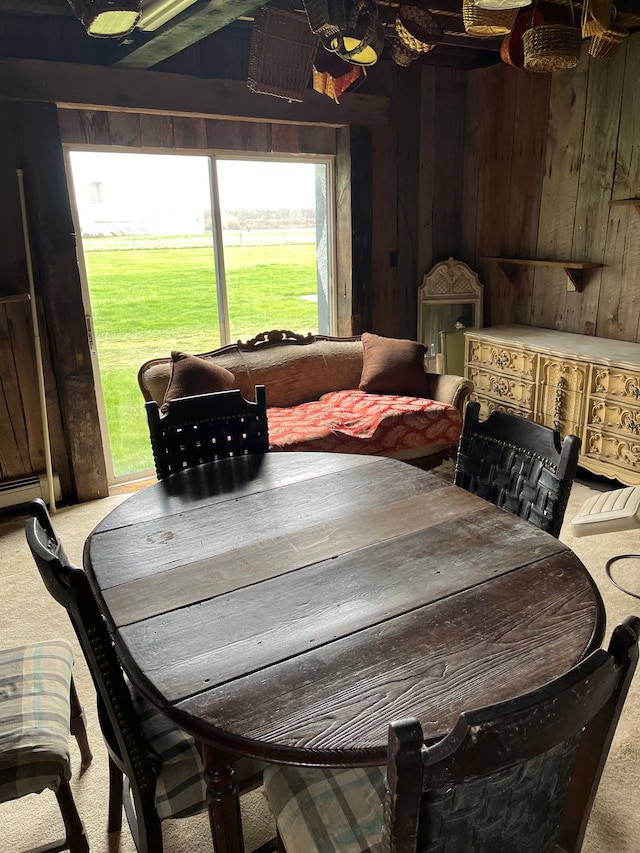 dining space featuring carpet floors, a wealth of natural light, and wooden walls